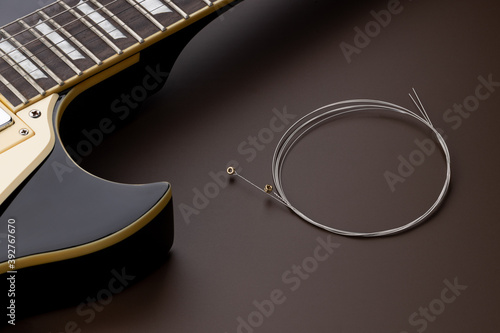 new music strings for electric guitar on a brown background. studio shot. space. restring concept. preparation to performance photo