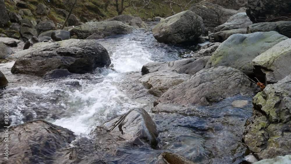 Rocky waterfall river creek flowing over boulders in seasonal Autumn woodland dolly right Rocky waterfall river creek flowing over boulders in seasonal Autumn woodland dolly right