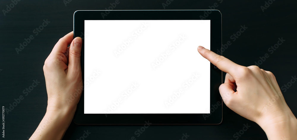 Tablet computer with white blank screen in hands isolated on black background. Holding and pointing to empty screen on digital tablet. Copy space. Tablet computer with white blank screen in hands isolated on black background. Holding and pointing to empty screen on digital tablet. Copy space.