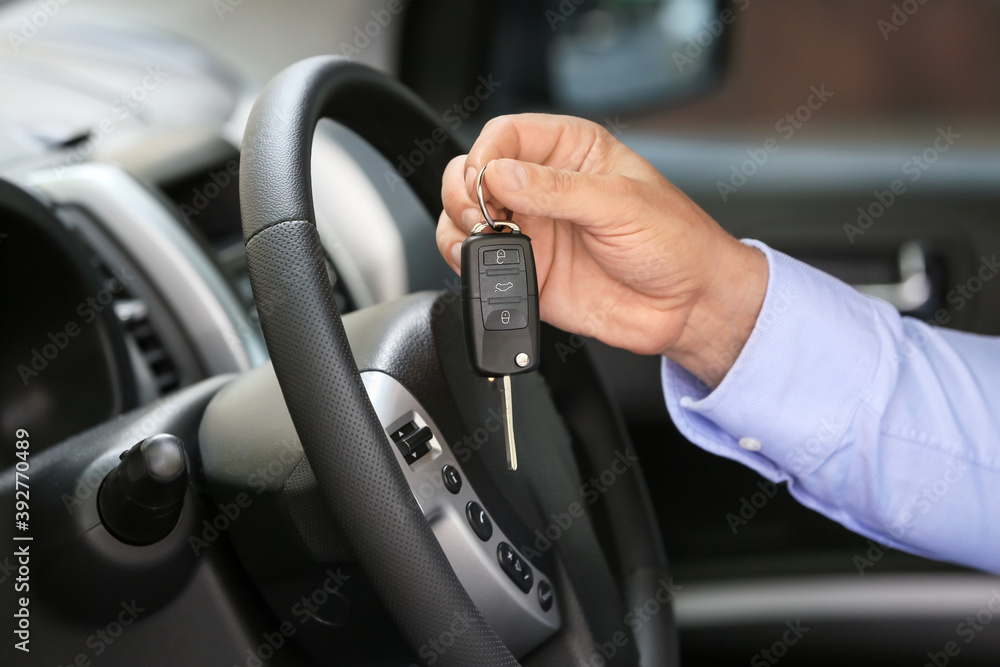 Man with key in car salon Man with key in car salon