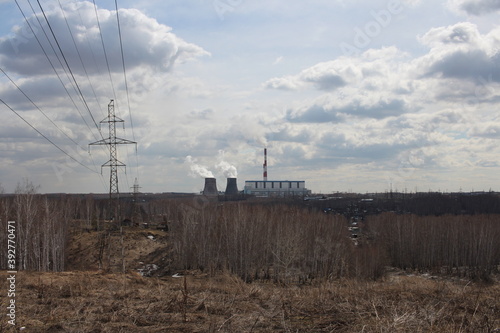 hills in the forest with a high iron electric tower power lines for high-voltage wires in CHP cooling towers