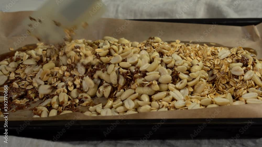 A nutritious blend of oatmeal, bran, a mixture of nuts, flax seeds and honey.The process of preparing a healthy Breakfast, muesli, on a baking sheet with parchment. A nutritious healthy Breakfast. Mix A nutritious blend of oatmeal, bran, a mixture of nuts, flax seeds and honey.The process of preparing a healthy Breakfast, muesli, on a baking sheet with parchment. A nutritious healthy Breakfast. Mix