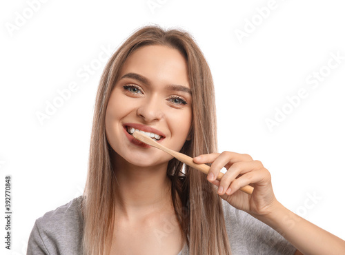Young woman with wooden tooth brush on white background
