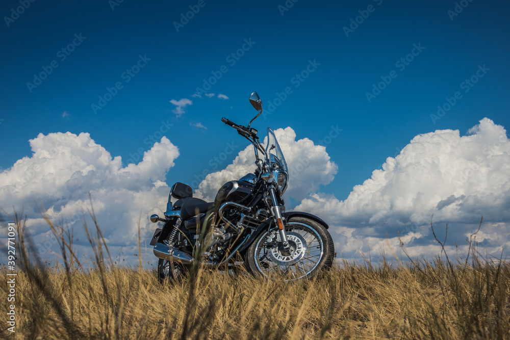 motorcycle on a background of clouds and yellowed grass motorcycle on a background of clouds and yellowed grass