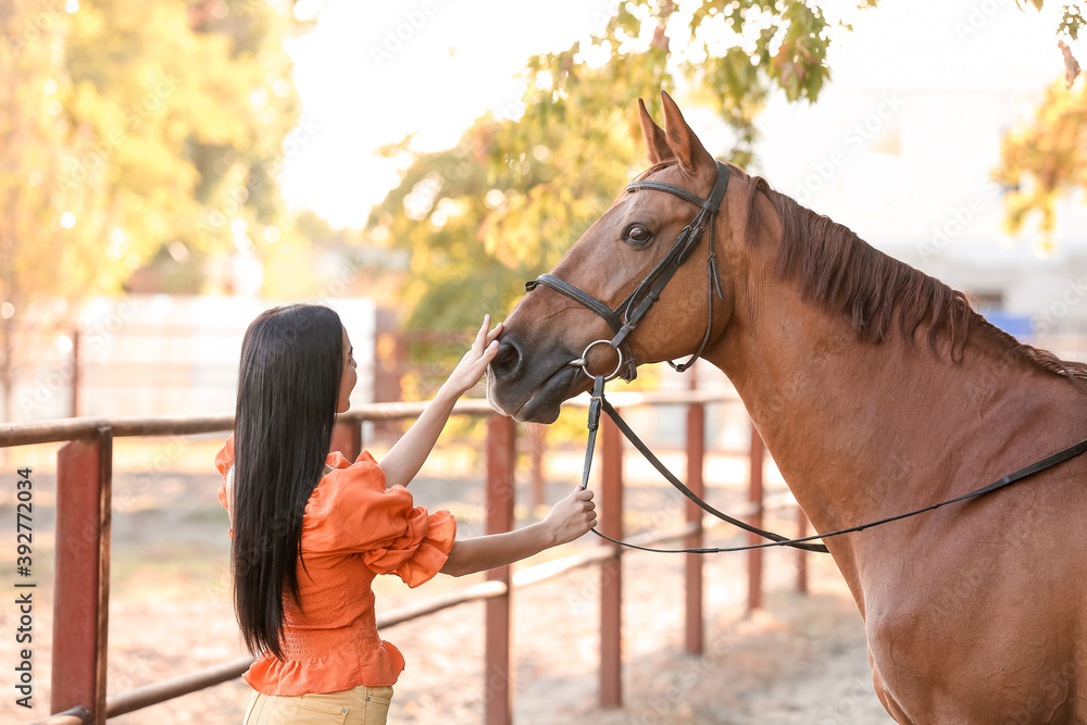 Obraz premium Beautiful young woman with cute horse outdoors
