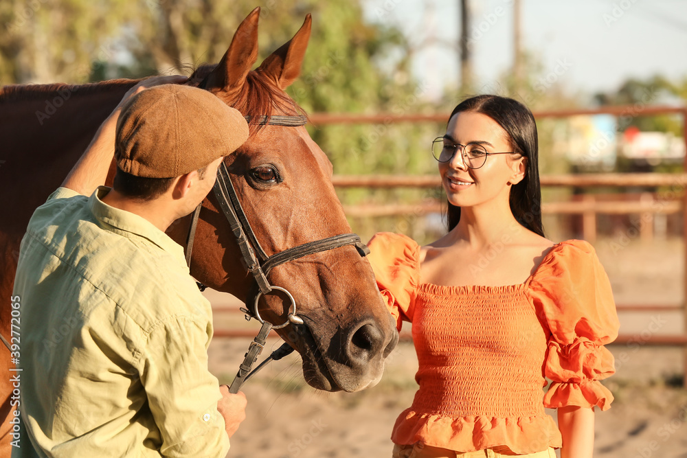 Obraz premium Young couple with cute horse outdoors