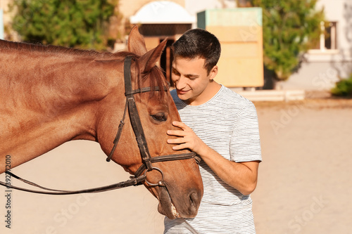 Young man with cute horse o...