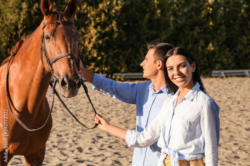 Young couple with cute horse outdoors © Pixel-Shot