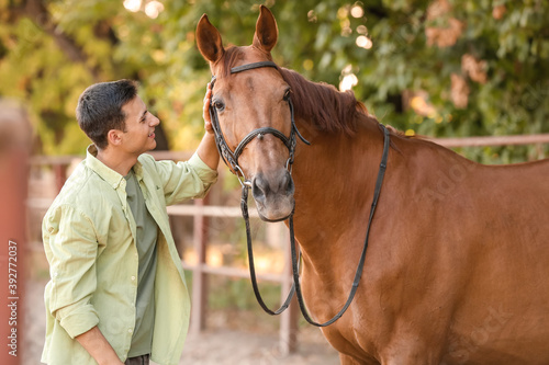 Young man with cute horse o...