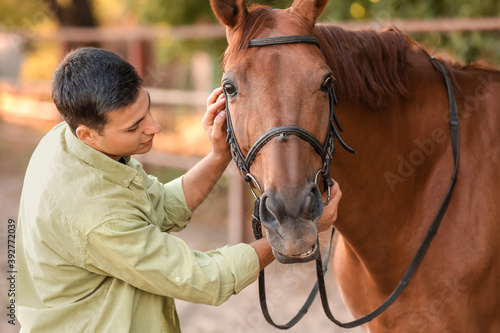 Young man with cute horse o...
