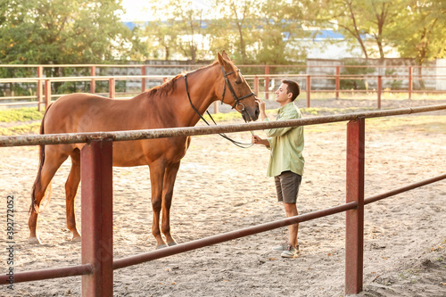 Young man with cute horse o...