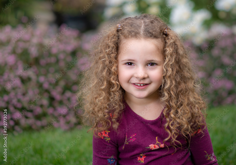 Outdoor portrait smiling adorable toddler girl with beautiful curly light brown hair Outdoor portrait smiling adorable toddler girl with beautiful curly light brown hair