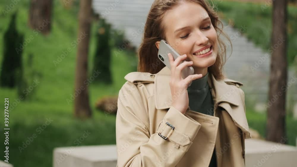 Portrait of pretty student girl having conversation with friend talking on smartphone and smiling outdoor Portrait of pretty student girl having conversation with friend talking on smartphone and smiling outdoor