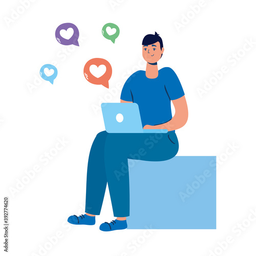 young man seated using laptop and social media icons