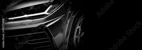 Fotografie Detail on one of the LED headlights super car on black background, free space on right side for text