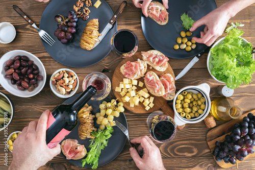 Dinner table concept. Top view of family or friends having dinner together on rustic wooden table