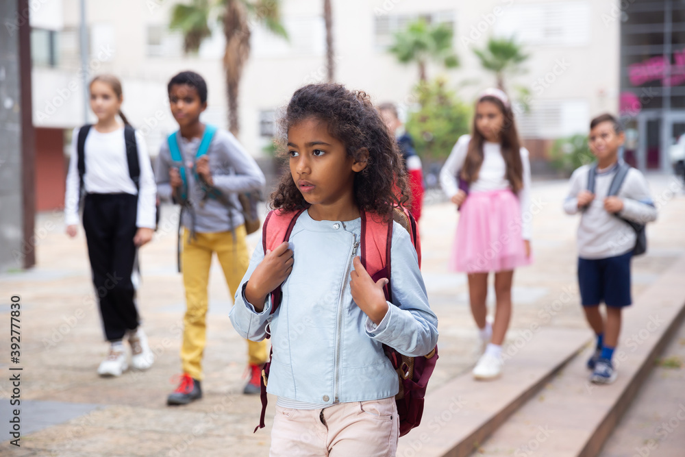 © JackF - Portrait of african american preteen girl with rucksack walking outdoors on her way to school on warm autumn day. Back to school concept.