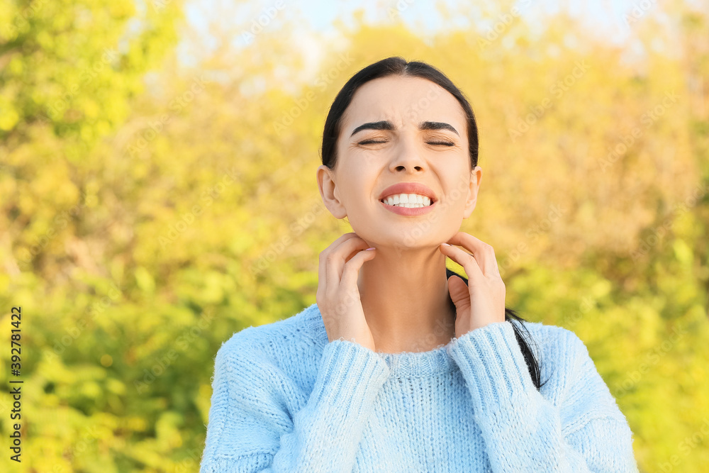 Allergic young woman scratching herself outdoors Allergic young woman scratching herself outdoors