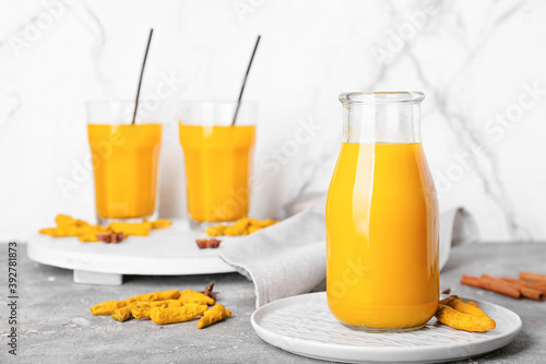 Bottle of healthy turmeric drink on table