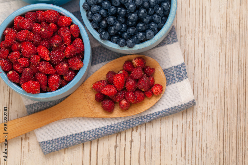 Organic bilberry and strawberry on wooden background, healthy food concept Organic bilberry and strawberry on wooden background, healthy food concept