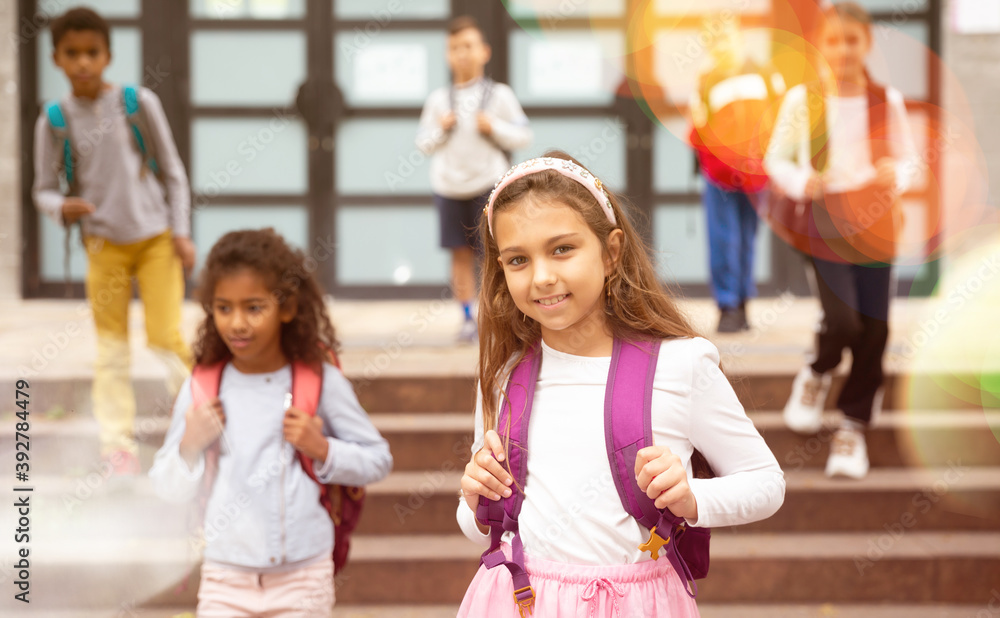 Fototapeta premium Portrait of smiling tween schoolgirl with backpack on her way to school on autumn day. Back to school concept.