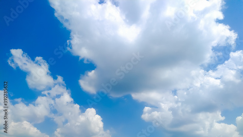 Huge cumulus clouds in blue sky flowing with wind