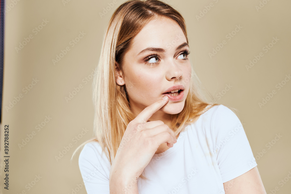 Cheerful woman in a white T-shirt gestures with her hands emotions beige background Cheerful woman in a white T-shirt gestures with her hands emotions beige background