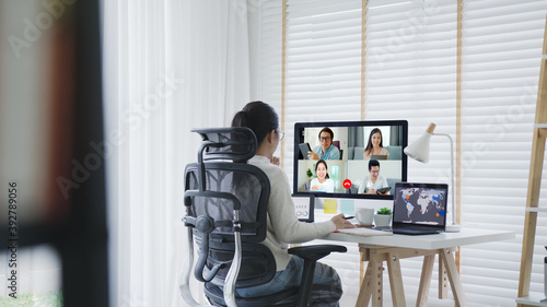 Business woman talking about sale report in video conference.Asian team using laptop and tablet online meeting in video call.Working from home,Working remotely and Self isolation at home photo