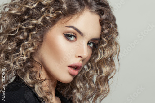 Attractive model woman with afro curly hair on white background portrait