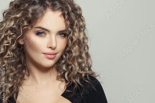 Cute young model woman with curly hair on white, fashion beauty portrait