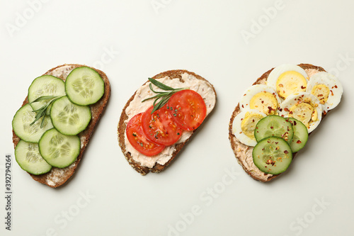Fotografie Tasty toasts with different topping on white background