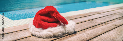 Christmas background banner santa claus red hat on swimming pool vacation holiday resort horizontal header for south holidays winter vacations. photo