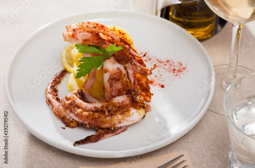 Plate of appetizing roasted shrimps served with lemon and herbs