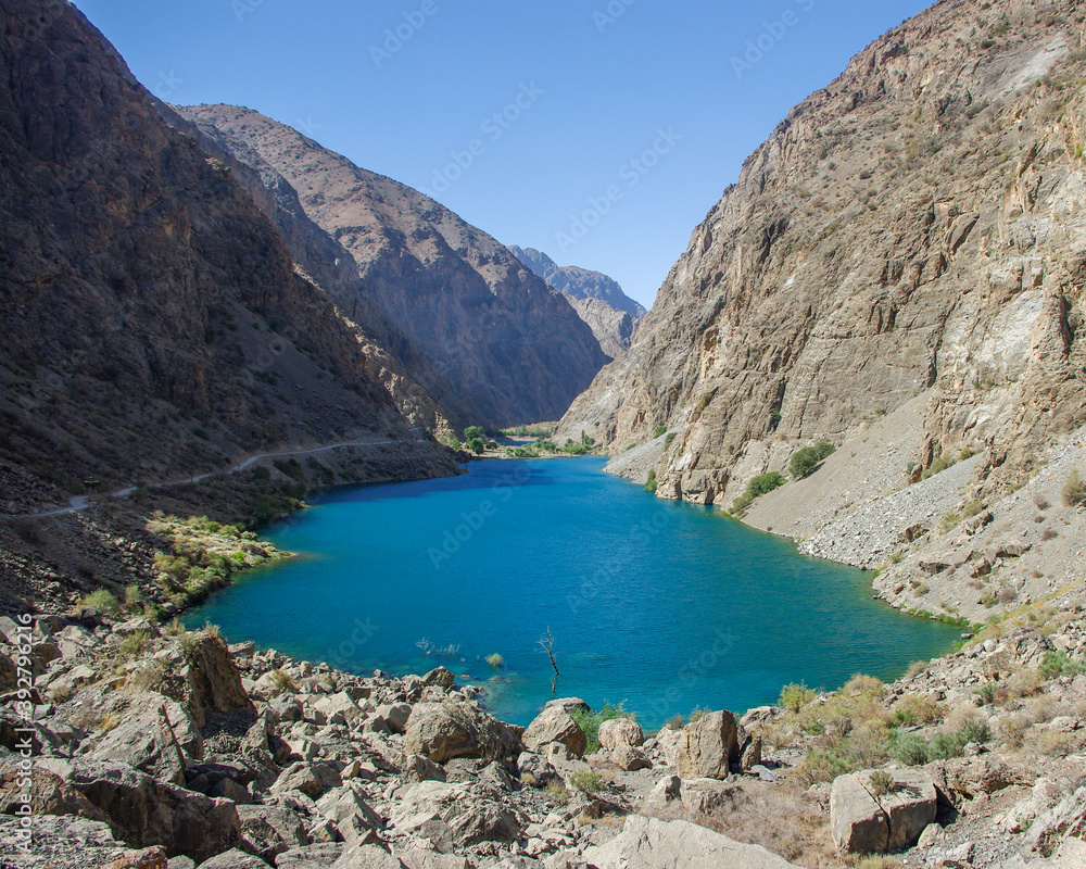 Obraz premium Turquoise blue Gushor lake in scenic mountain landscape in the Marguzor seven lakes area, Shing river valley, Fann mountains, near Penjikent or Panjakent in Tajikistan