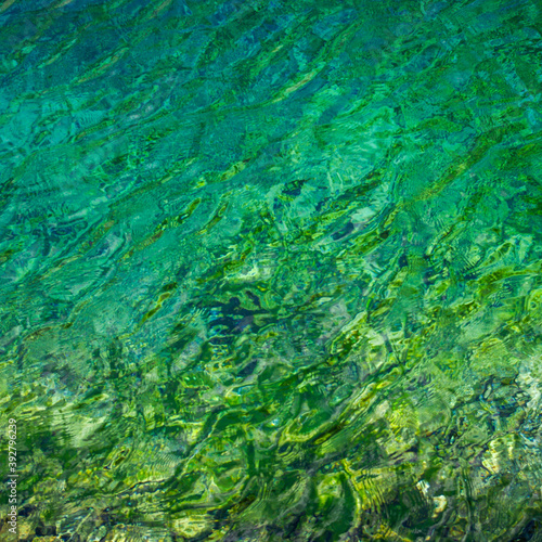 Abstract image of ripples in the pure water of translucent turquoise mountain lake in Marguzor, Tajikistan