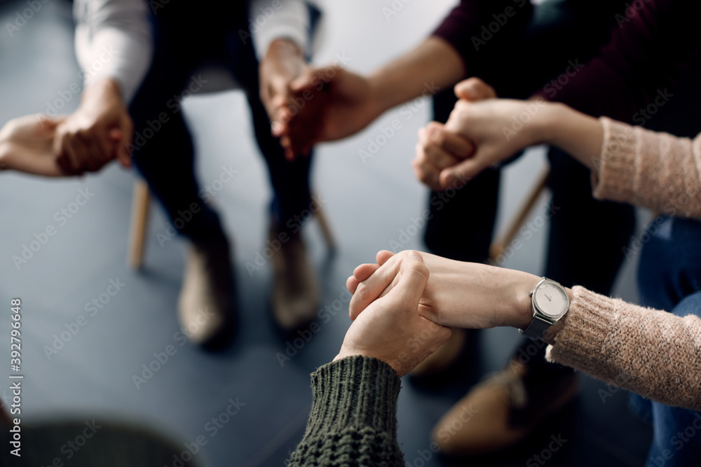 Close-up of attenders of group therapy holding hands during the meeting. Close-up of attenders of group therapy holding hands during the meeting.