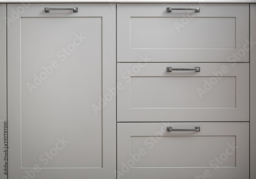 Foto White kitchen cabinets with metal pulls or knobs on the doors.