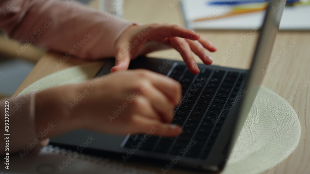 Girl hands typing computer keyboard indoors. Kid using laptop for schooling. Girl hands typing computer keyboard indoors. Kid using laptop for schooling.