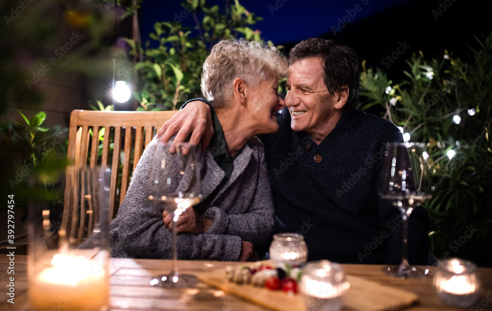 Senior couple with wine in the evening on terrace, hugging. Senior couple with wine in the evening on terrace, hugging.