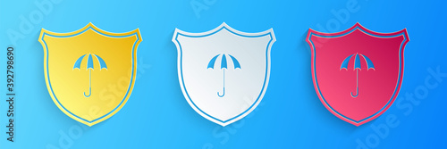 Paper cut Waterproof icon isolated on blue background. Shield and umbrella. Water protection sign. Water resistant symbol. Paper art style. Vector.