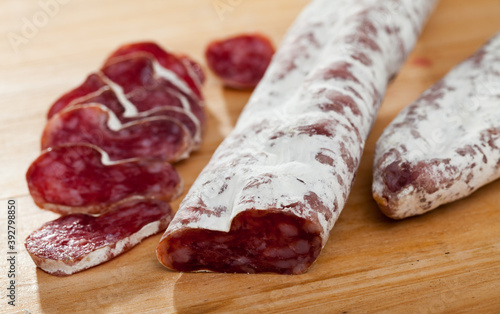 Spanish sausage fuet on a wooden table, closeup. High quality photo