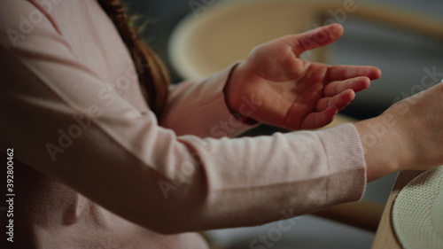 Unknown girl hands spraying antiseptic indoors. Schoolgirl sanitizing hands.