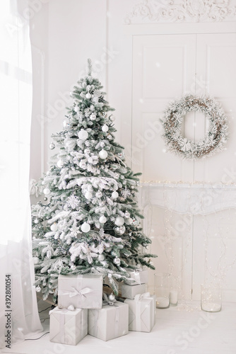 Festive interior. Luxurious Christmas tree decorated with lights with gifts. Happy New Year 2021. Christmas concept. Soft selective focus. Copy space.