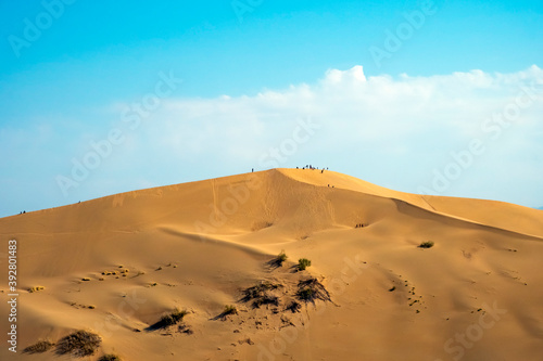 Sand dunes with clouds backgorund. Natural landscape. Altyn-Emel singing dunes or barkhan. Altyn-emel national park in Kazakhstan. Tourism travel in Kazakhstan concept.