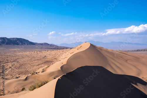 Sand dunes with clouds backgorund. Natural landscape. Altyn-Emel singing dunes or barkhan. Altyn-emel national park in Kazakhstan. Tourism travel in Kazakhstan concept.