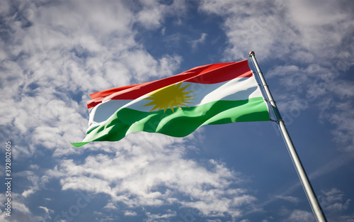 Bild auf Leinwand Kurdistan national flag waving at sky background close-up.