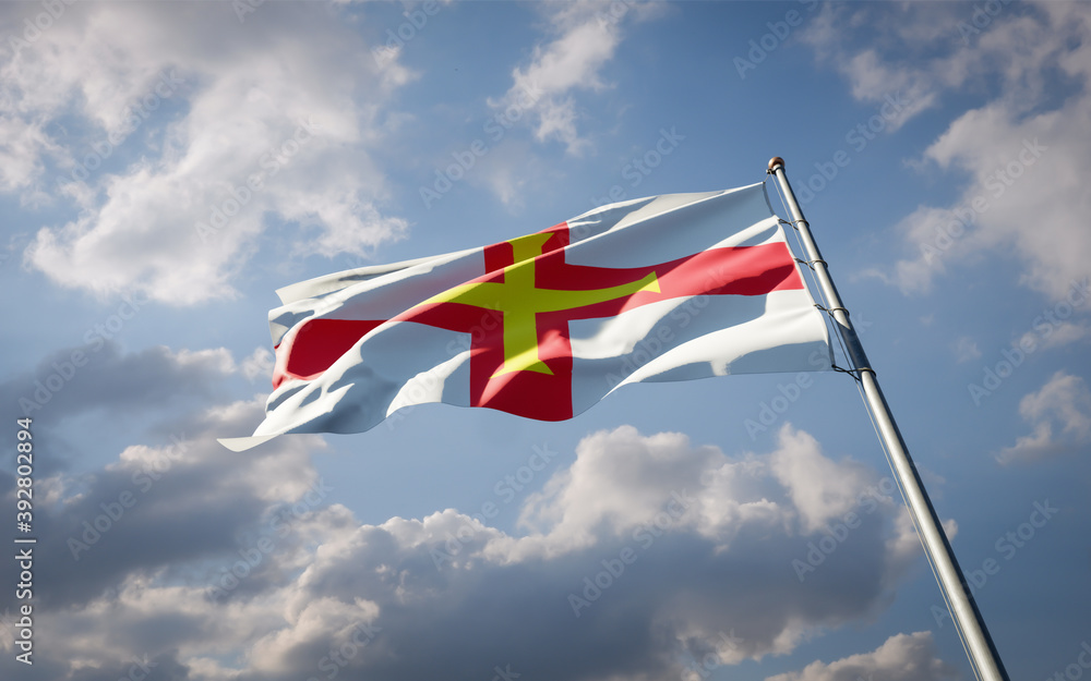 Guernsey national flag waving at sky background close-up. Guernsey national flag waving at sky background close-up.