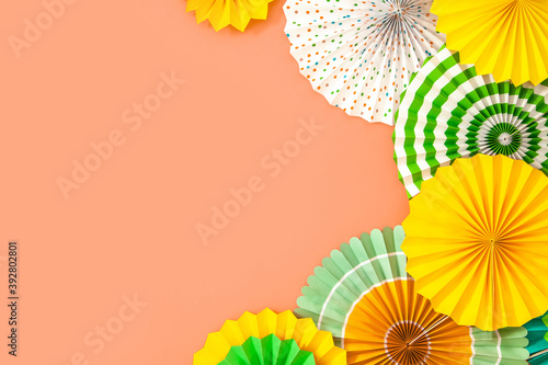 Colorful paper rosette and birthday garlands. Decorating for a party. Round  bright and color decoration. Coral background.