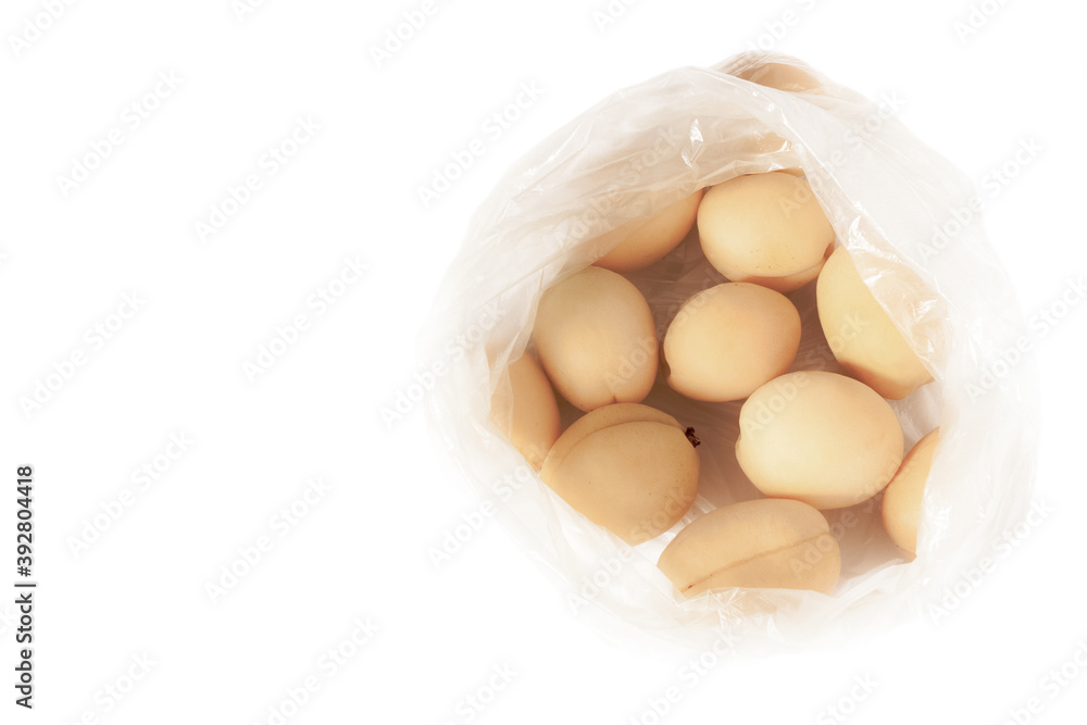 Fresh apricots in plastic cellophane transparent package above view retro style. Fresh apricots in plastic cellophane transparent package above view retro style.