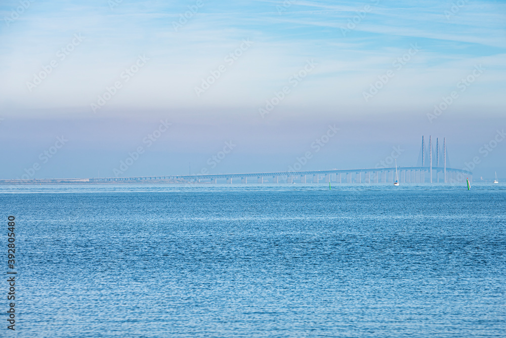 Amid the fog or mist, the Oresund Bridge or Oresundsbron lies on a calm Baltic sea as commuters cross the Oresund strait  between the Danish capital Copenhagen and Malmo, Sweden - Dragor, Denmark